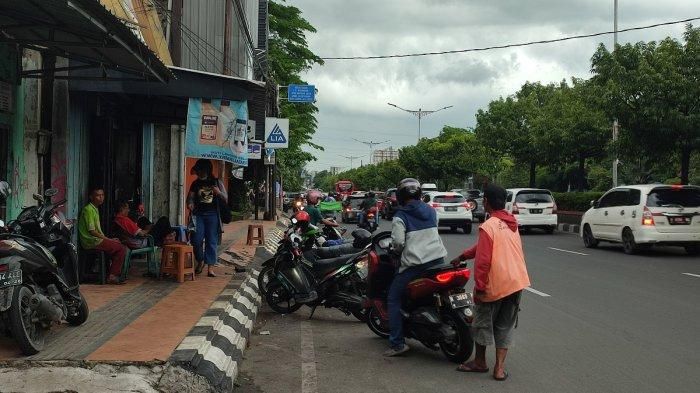 Juru parkir (Jukir) sedang melayani pengguna parkir yang hendak pergi di Jalan Mgr Suyigopranoto, Bulustalan, Semarang Selatan, Kota Semarang (18/2/2023). 