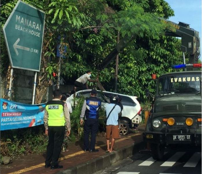 Proses evakuasi Daihatsu Xenia terjungkal ke kebun usai tabrak tiang listrik dan tembok di dekat pintu tol Mumbul, Kuta Selatan, Badung, Bali