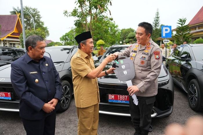 Prosesi serah terima mobil dinas listrik Toyota bZ4X dari Gubernur Riau, Syamsuar ke Kapolda Riau, Irjen Pol Muhammad Iqbal