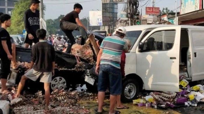 Warga evakuasi telur yang pecah setelah Suzuki Carry pengangkut ditabrak Honda Mobilio dan Daihatsu Gran Max di Tapos, kota Depok, Jawa Barat