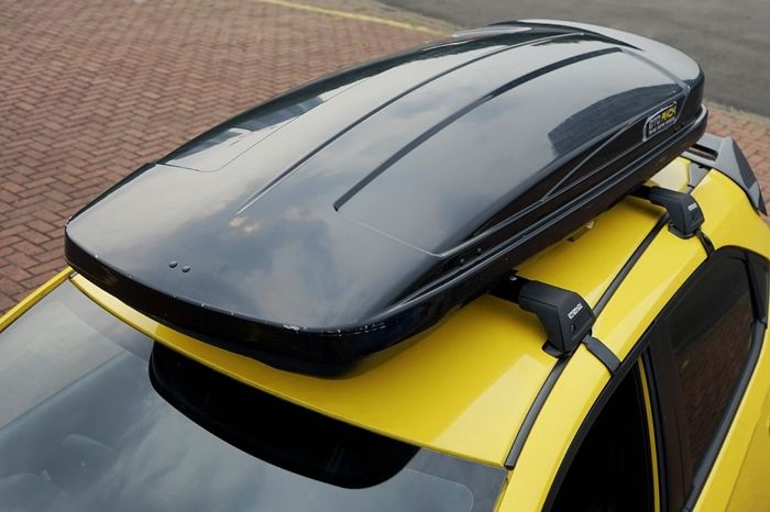 Contoh pemasangan roof box dengan cross bar universal yang dijepit ke bodi mobil.