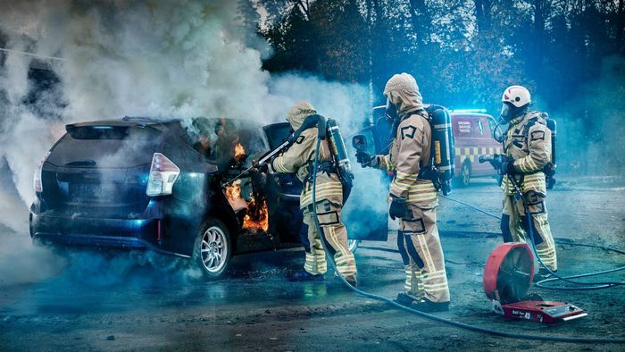 Ilustrasi petugas pemadam kebakaran sedang memadamkan mobil yang terbakar