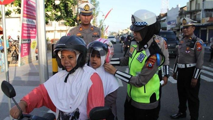 Anggota Polwan Satlantas Polres Ponorogo bagikan helm ke pengendara motor secara gratis
