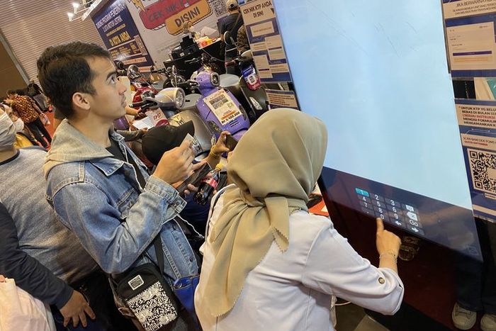 Pengunjung Jakarta Fair 2023 melakukan cek penerima Subsidi Motor Listrik(KOMPAS.com/daafa) 