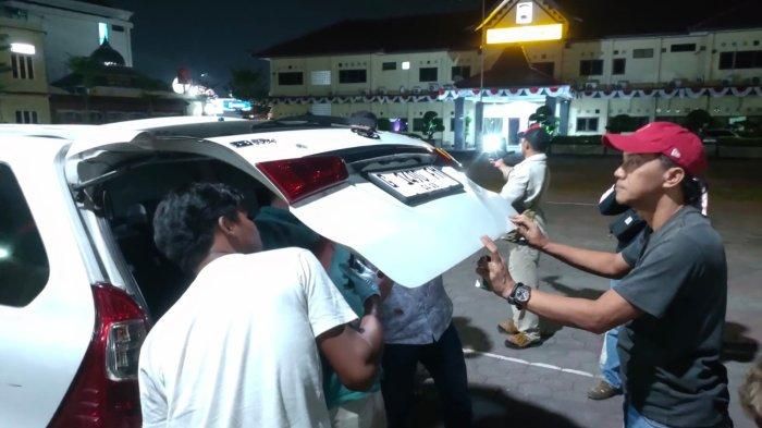 Tim Inafis Polres Tegal memeriksa pintu bagasi Toyota Avanza ormas LMPI yang ditembali OTK
