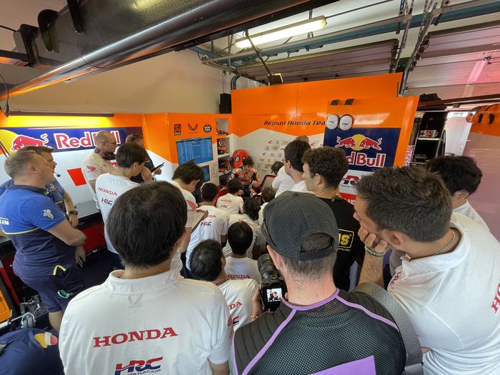 Suasana garasi tim Repsol Honda saat Tes MotoGP di Sirkuit Misano, Rimini, Italia, 11 September 2023. Tampak kerumunan teknisi berkumpul untuk mendengarkan umpan balik dari Marc Marquez.