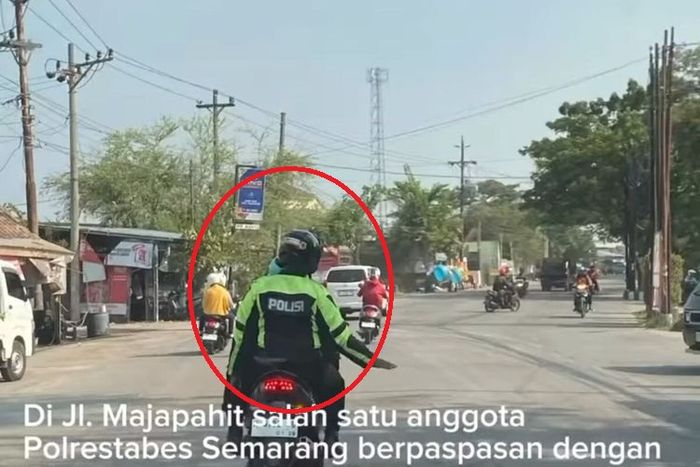 Dalam lingkaran merah, oknum Polisi gadungan modal jaket bertuliskan POLISI beraksi di jalan