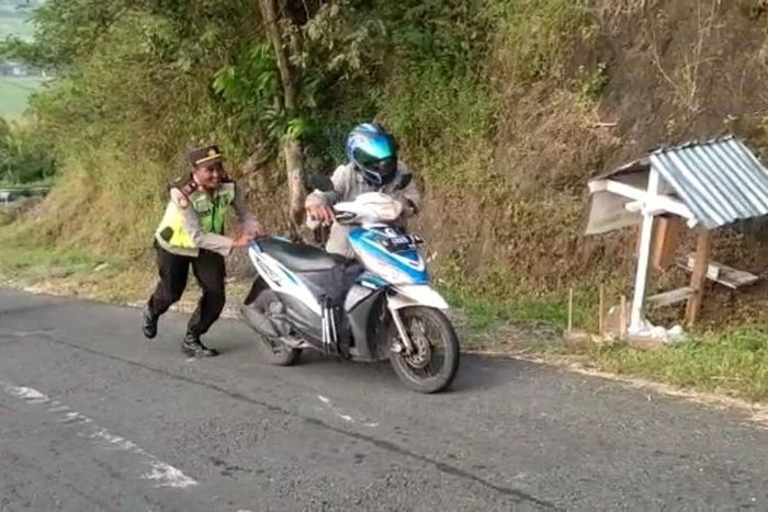 Polisi mendorong sepeda motor di tanjakan Clongop, Gunungkidul DI Yogyakarta.(Dok Polsek Gedangsari)  