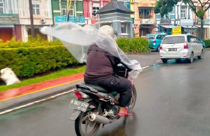 Ilustrasi jas hujan ponco yang berbahaya buat keselamatan pemotor.