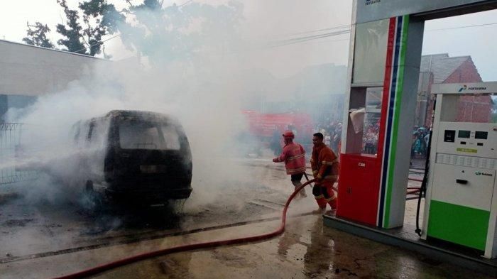 Petugas pemadam berusaha memadamkan api yang membakar Suzuki Carry Futura di SPBU Jl KH Saleh, Kandang sapi, Sindang Asih, Karangtengah, Cianjur