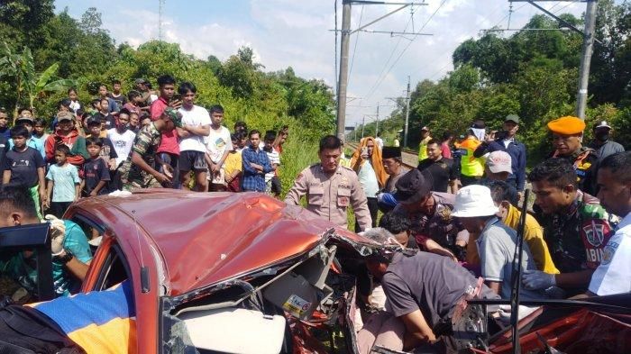 Proses evakuasi dua jasad korban dari dalam kabin Toyota Agya yang tertabrak KRL di desa Cilaku, Tenjo, kabupaten Bogor