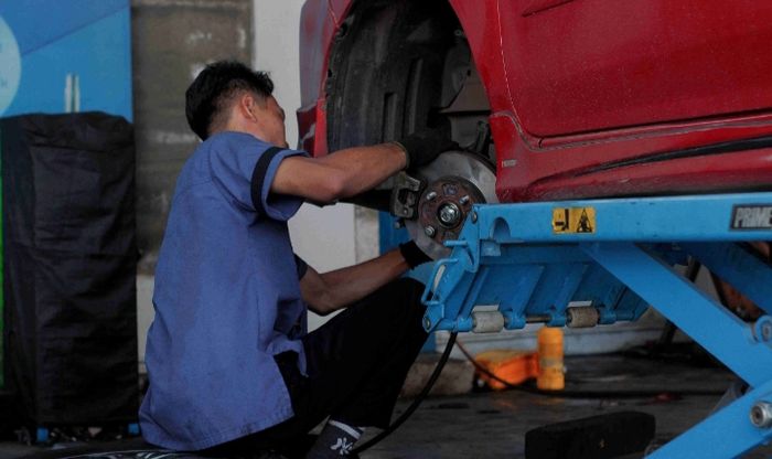 Ilustrasi perbaikan kaki-kaki mobil di bengkel Jantrakakikaki