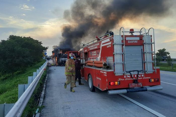 Petugas pemadam kebakaran berusaha memadamkan api yang melahap bus PO Pahala Kencana di ruas tol Jombang-Mojokerto
