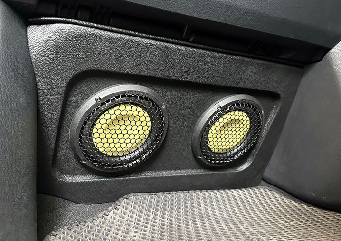 Dua subwoofer audio mobil di kolong dashboard depan.