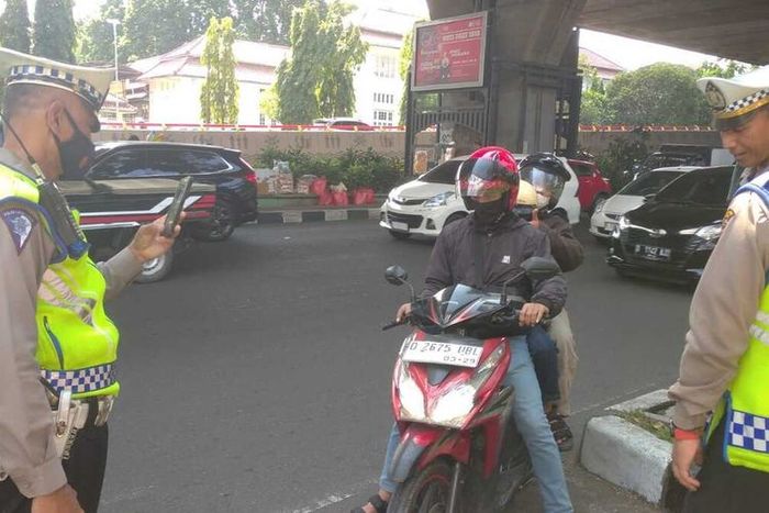 Anggota Satlantas Polrestabes Bandung menilang elektronik pengendara motor dengan cara memfoto-nya