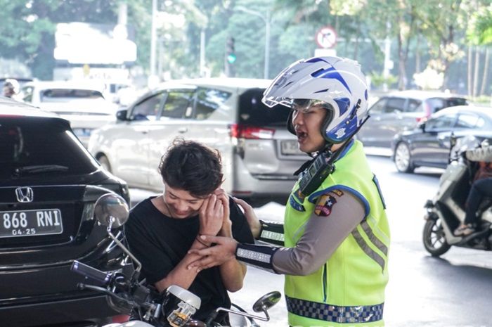 Foto ilustrasi. Pemotor diberhentikan polisi karena enggak pakai helm di razia Operasi Patuh Jaya 2024.