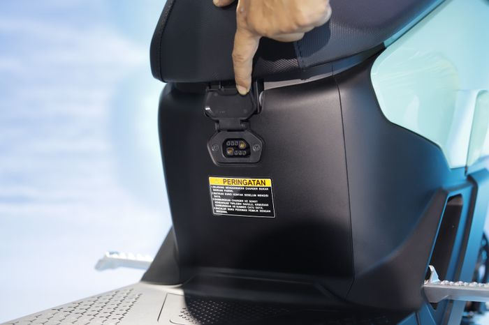 Soket pengecasan Honda ICON e: terletak di bawah jok bagian depan