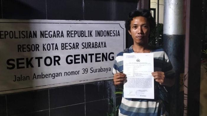 Alhamda Iqbal menunjukkan surat laporan polisi. 