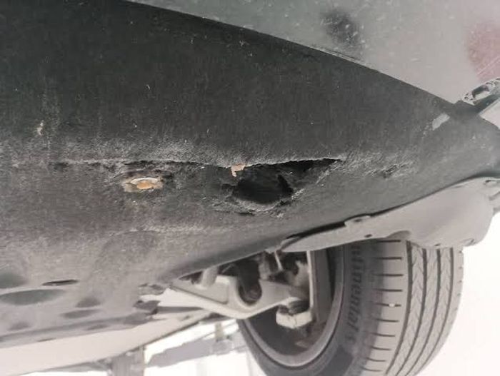 Cover plastik kolong mobil BYD Seal yang rentan bolong atau pecah.