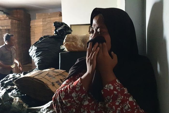 Momen Yuli menangis ketika di ajak petugas naik ke lantai dua tempatnya bekerja, karena selama dua minggu tak tahu jika menjadi gudang penyimpanan oli palsu di Kompleks Harmoni Warehouse No 8K, Percut Sei Tuan, Deli Serdang, Sumatera Utara