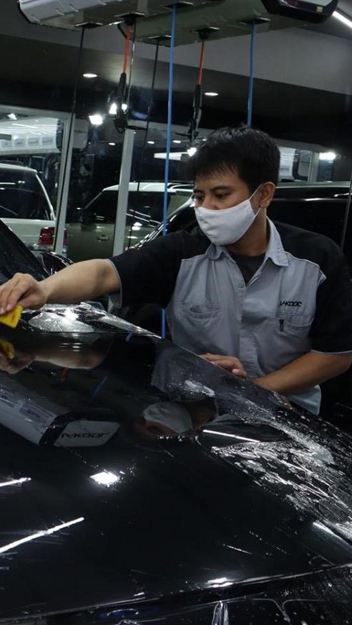Teknisi memasang V-Kool PPF di bodi mobil