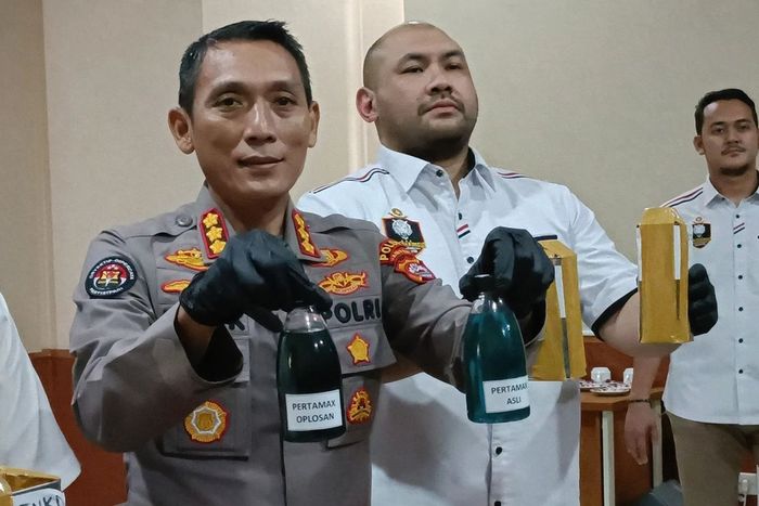 Polisi menunjukan perbedaan Pertamax murni dan Pertamax oplosan berwarna hitam pekat di SPBU 34.421.13 di Jl Jenderal Sudirman, Ciceri, Serang, Banten