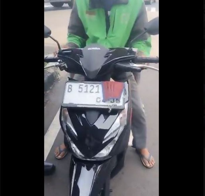 Bagian ujung belakang pelat nomor Honda BeAT milik pengendara ojek online yang ditutup masker hidung untuk hindari tilang elektronik