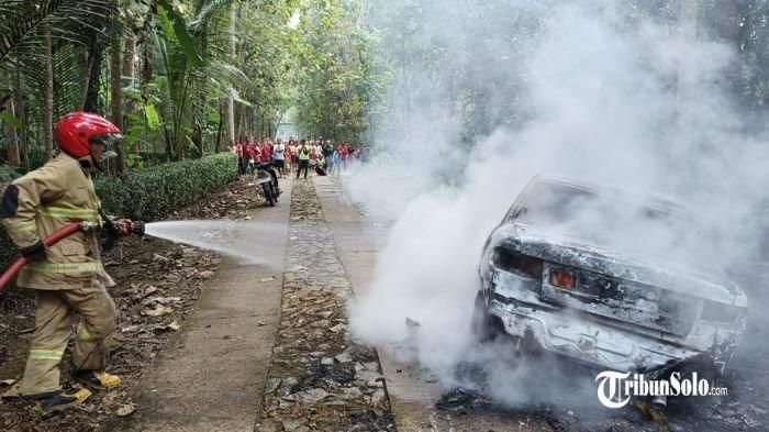 Petugas pemadam kebakaran menyemprotkan air ke sedan Timor S515 yang terbakar di jalan dusun Lalung Kidul RT 4 RW 2, Desa Mlokomanis Wetan, Kecamatan Ngadirojo, Wonogiri, Jawa Tengah