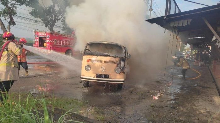 Petugas pemadam kebakaran menyemprotkan air ke VW Kombi yang terbakar hebat di Jl Wates, padukuhan Klangon, Argosari, Sedayu, Bantul, Yogyakarta
