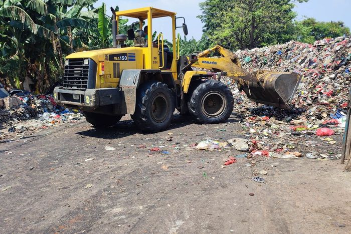 Alat berat mulai bekerja mengangkuti sampah yang menggunung menutup akses jalan di Penggilingan, Cakung, Jakarta Timur