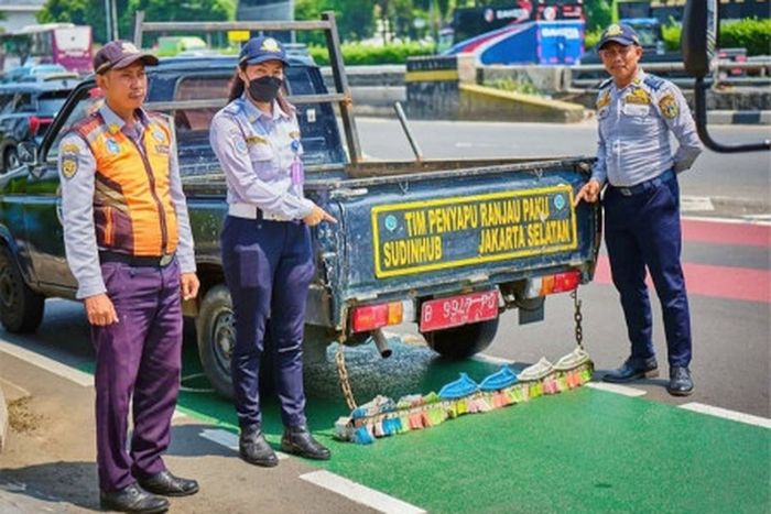 Tim sapu Ranjau Paku dari Suku Dinas Perhubungan dan Satuan Polisi Pamong Praja (Satpol PP) Jakarta Selatan.