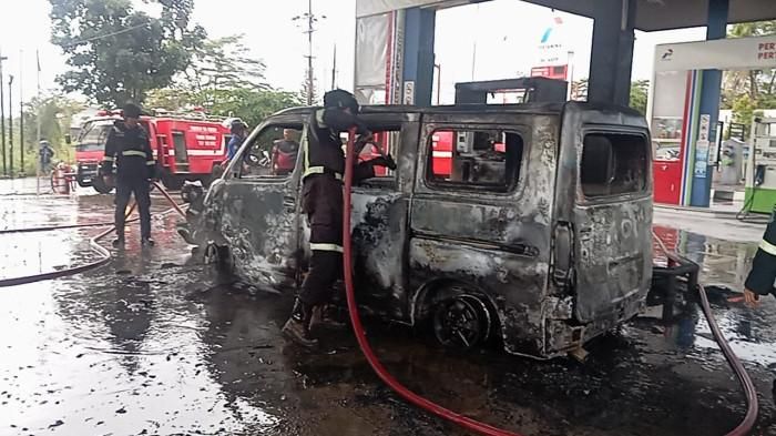 Petugas pemadam kebakaran menyemprotkan air ke Daihatsu Gran Max yang terbakar di SPBU Mandirancan, Kuningan, Jawa Barat