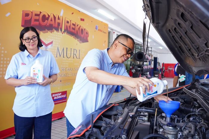 Martogi Siahaan, Direktur PT Astra Otoparts (kanan) dan Kartika Pelapory, Vice President Marketing Manager Lubricants Shell Indonesia secara simbolis melakuan pergantian oli mobil ter