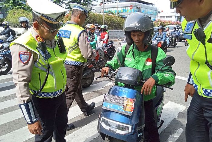 Pengendara ojek online terjaring Operasi Zebra Jaya 2025 di simpang Tomang Raya, Jakarta Barat karena menutupi sebagian pelat nomor menggunakan stiker untuk hindari tilang ETLE