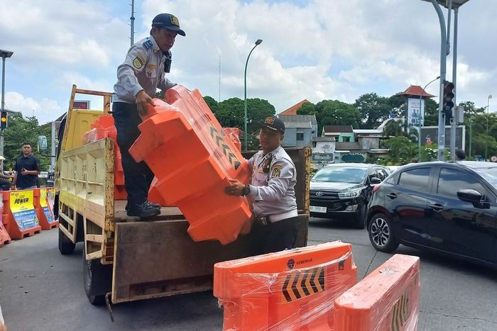 Petugas Dinas Perhubungan kota Yogyakarta menurunkan water barrier untuk melakukan rekayasa lalu lintas selama penutupan jembatan Kewek untuk perbaikan