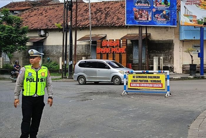 Rambu imbauan pengalihan arus lalu lintas Semarang-Grobogan yang lumpuh akibat tanggul sungai Tuntang jebol dari Satlantas Polres Blora di tugu Pancasila Blora, Jawa Tengah