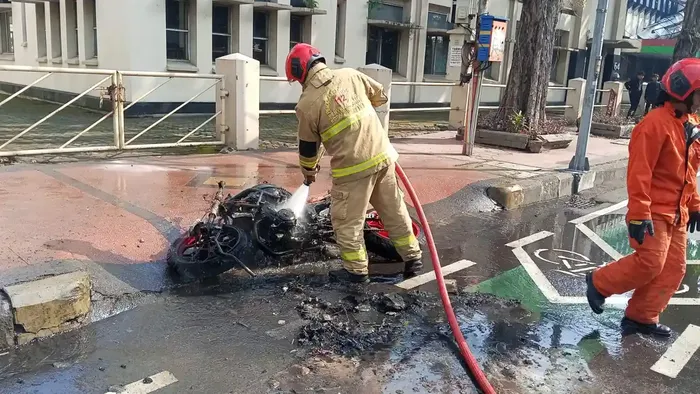 Proses pendinginan oleh petugas pemadam kebakaran terhadap motor Yamaha MT-25 yang terbakar di Jalan Panglima Sudirman, Genteng, Surabaya, Jawa Timur