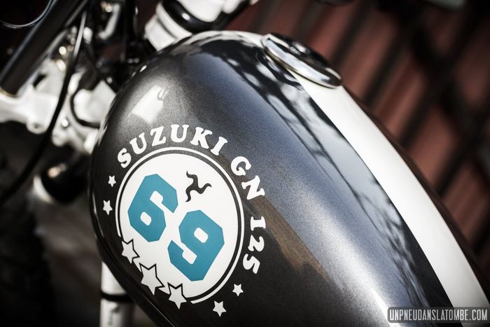 Laburan warna abu-abu metalik dan putih pada tangki Suzuki GN125 custom street tracker dari Kamaji