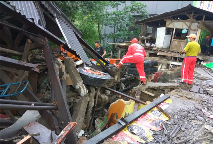Tim penyelamat segera mengevakuasi truk yang menabrak warung makan 