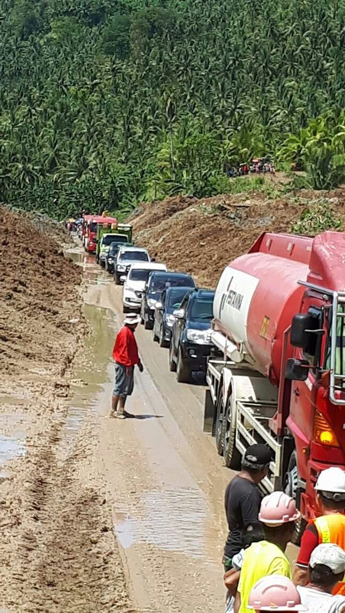 Mobil yang mencoba melewati jalur Jalan Trans Sulawesi di Sinonsayang