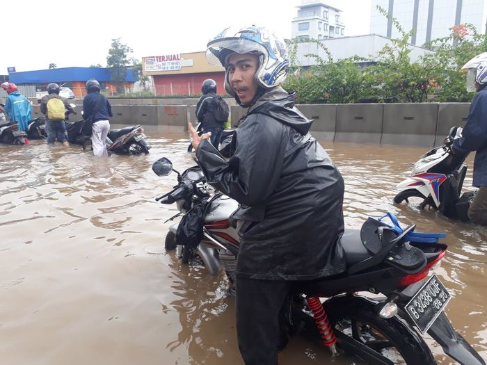 Pengendara motor yang terjebak banjir di Jakarta Utara