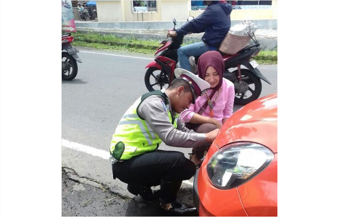 Pemasangan plat nomor yang dilakukan polisi untuk mobil pelanggar