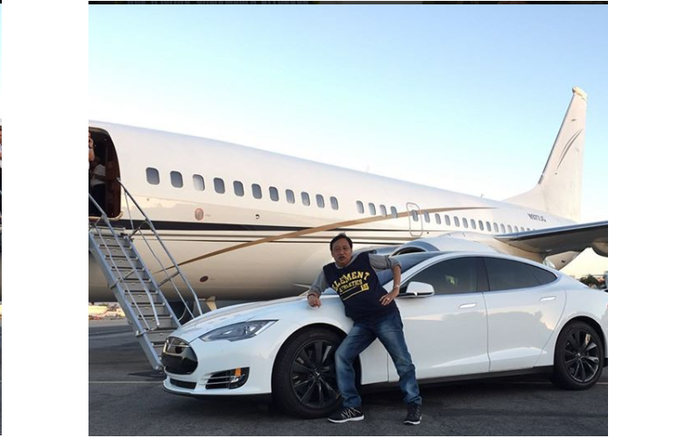 Doyok berpose dengan mobil Tesla model S