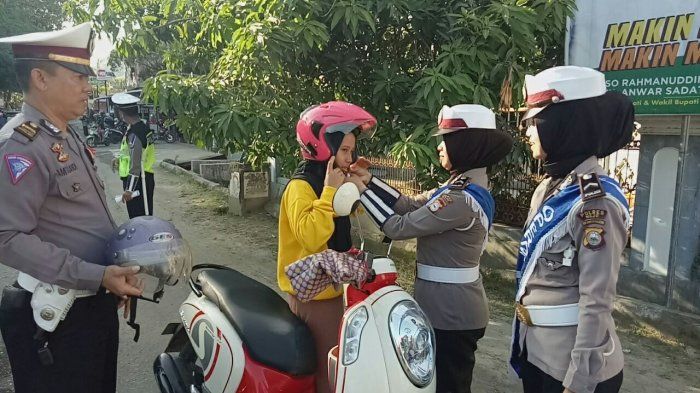 Polantas memberikan helm SNI bagi pengendara sepedamotor