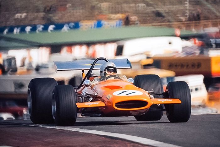Bruce McLaren dengan mobil Mclaren warna pepaya