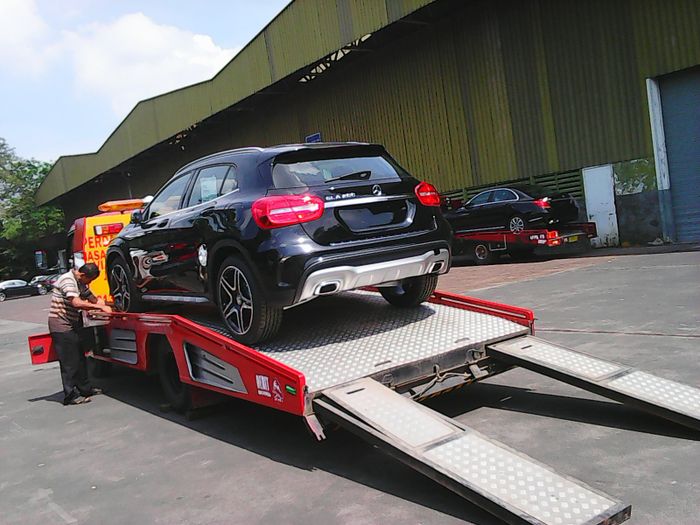 Ilustrasi mobil dibawa dengan derek gendong atau towing flat deck