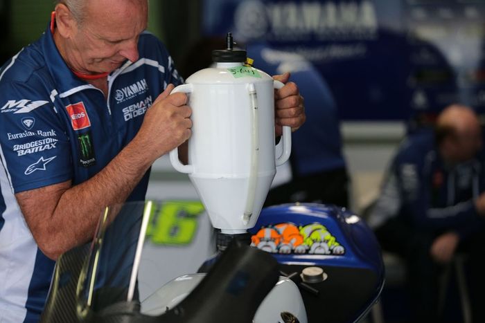 Seorang teknisi sedang mengisi bahan bakar motor YZR-M1 Valentino Rossi