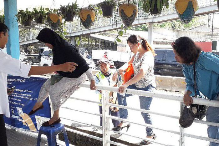 Tidak bisa melalui jembatan, pengguna Transjakarta harus loncat pagar