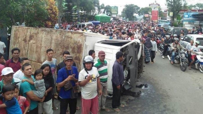 Warga menyaksikan bangkai kendaraan yang dihantam truk dalam kecelakaan maut di depan RS Muhammadiya