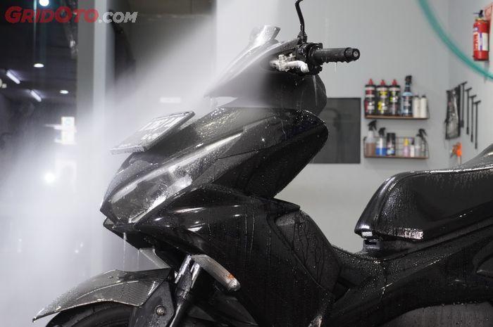 motor yang sedang dicuci setelah terkena banjir